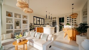 A modern living room with a sofa, coffee table, and shelves with decorative items. - Villa Yuni Uluwatu (Pecatu)