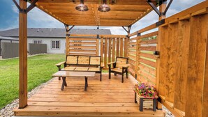 A wooden deck with a bench and table, surrounded by a wooden fence.