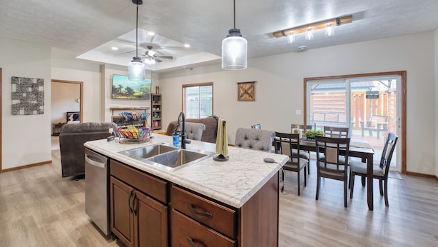 A spacious kitchen with a large island, a dining area with a table and chairs, and a living room with a sofa and a television.