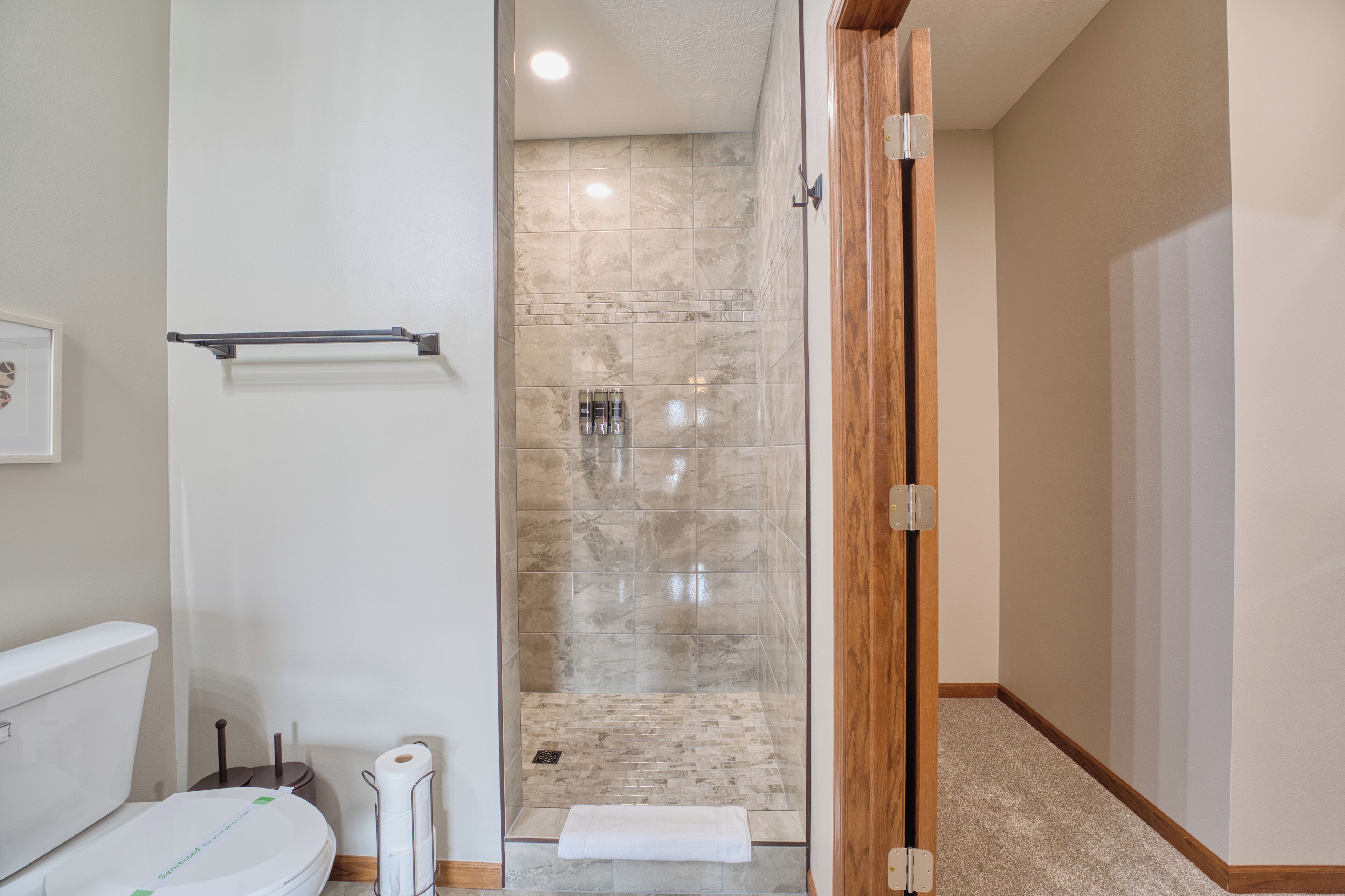 Un baño moderno con ducha de vidrio, inodoro y barra para toallas.