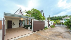 Ein modernes Haus mit überdachter Veranda, Garage und Auffahrt.