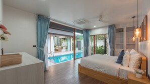 Ein modernes Schlafzimmer mit einem großen Bett, einem Nachttisch, einem Holzbeistelltisch und Blick auf einen Swimmingpool.