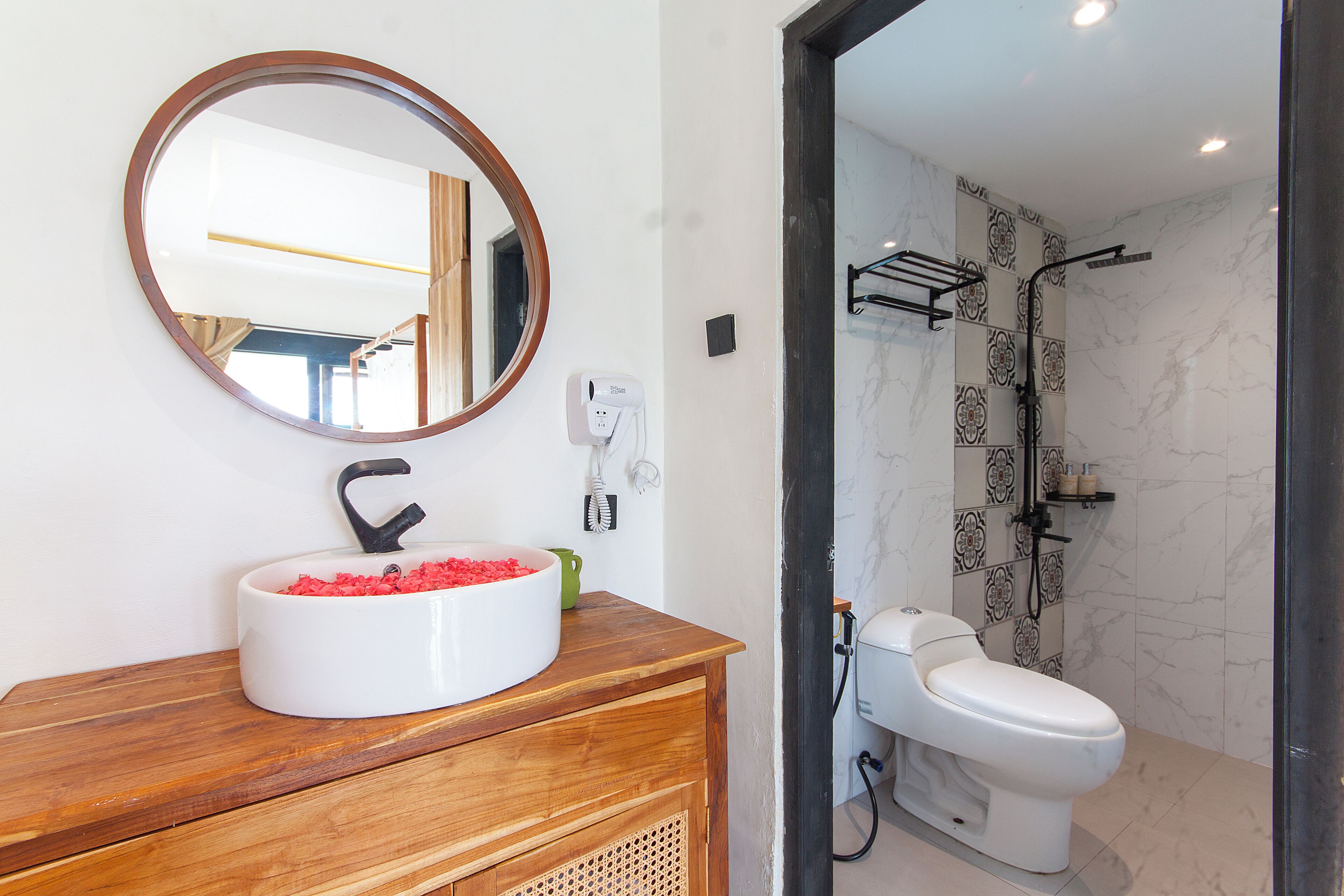 A bathroom with a white sink, a mirror, and a toilet.