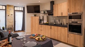 Eine moderne Küche mit Holzausbau, Edelstahlgeräten und einem Essbereich mit gedecktem Tisch.
