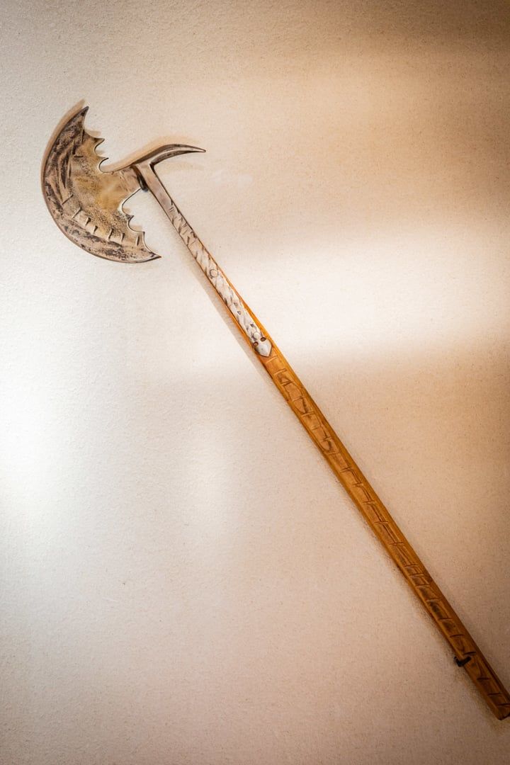 Un bastón de madera con cabeza de metal.