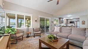 A spacious living room with a sofa, chairs, a coffee table, and a view of the outdoors through large windows. - Stylish 3BR Waterfront Home w/ Sunset Porch + Access to Dining Sunsets on Shoreline by Avantstay (Mooresville)