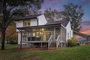 A two-story house with a covered porch and a staircase leading to the upper floor. - Stylish 3BR Waterfront Home w/ Sunset Porch + Access to Dining Sunsets on Shoreline by Avantstay (Mooresville)