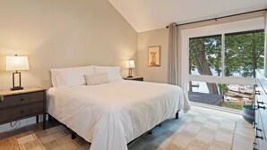 Una camera da letto con un letto grande, due comodini con lampade, una finestra vista esterna e una ventola a soffitto.