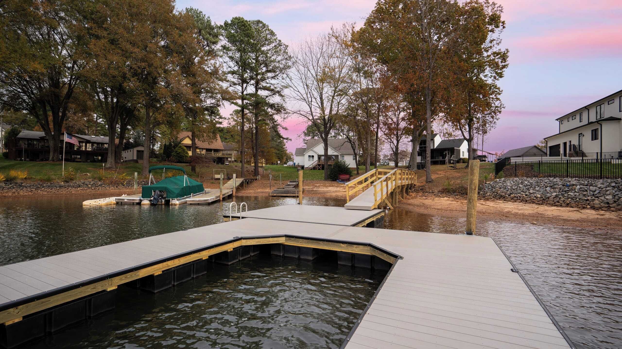 A dock extending into a body of water with a small boat covered by a green tarp.
