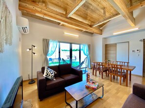 Una sala de estar con sofá, mesa de centro y comedor con sillas.