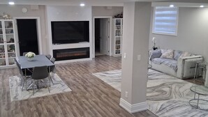 Un salon moderne avec une cheminée, un téléviseur et un canapé.