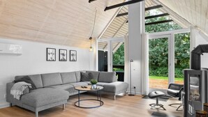 A modern living room with a grey sectional sofa, a round coffee table, and a fireplace.