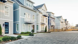 Una hilera de casas adosadas con entrada pavimentada y pequeños jardines delanteros.