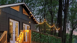 A modern wooden house with a deck, string lights, and a wooden staircase. - NEW Zen Cabin in the Clouds . Hot Tub, Wineries, Skyline  (Front Royal)