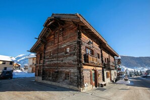 A rustic wooden building with a balcony, a snow-covered mountain in the background, and a clear sky. - Sforzato, Livigno, Italy (Livigno)