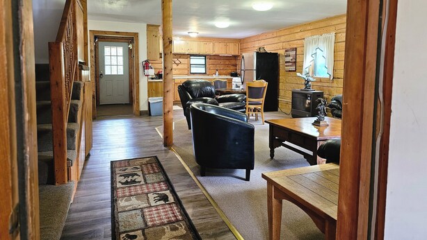 A cozy cabin interior with a living room, dining area, and kitchen.