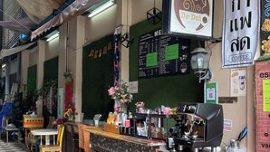 Ein Café mit Theke, Speisekarte und Sitzbereich.