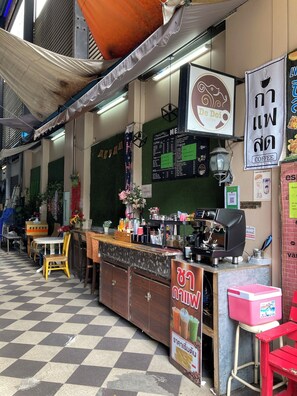 Una cafetería con mostrador, menú y zona de estar.