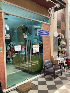 A storefront with a glass door, a sign indicating a free zone, and a no smoking, no food or drink, no pets policy. - Sleep Cafe at Hidee (Bangkok)