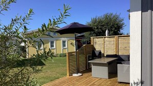 A wooden deck with outdoor furniture, a pergola, and a view of a house in the background. - 4 Star Holiday Home in Falkenberg (Falkenberg)