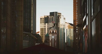 Un horizonte urbano con edificios altos, uno de ellos con una torre de reloj.