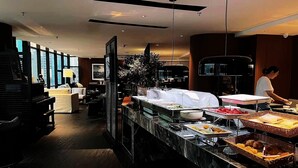 A hotel dining area with a buffet setup, a piano, and a seating area with a view of the city. - chongqingyinshiguangjiangjingjiudian (Chongqing)