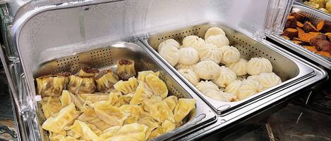 A buffet with various food items including dumplings and other dishes.