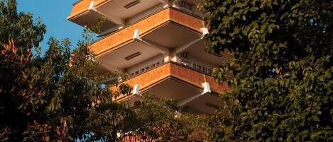 A multi-story building with a series of balconies and a chimney.