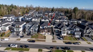 Área residencial com casas modernas, uma rua principal e um fundo arborizado.