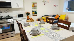 Eine kleine Küche mit Herd, Backofen und Essbereich, gedeckt mit Tellern und Schüsseln.