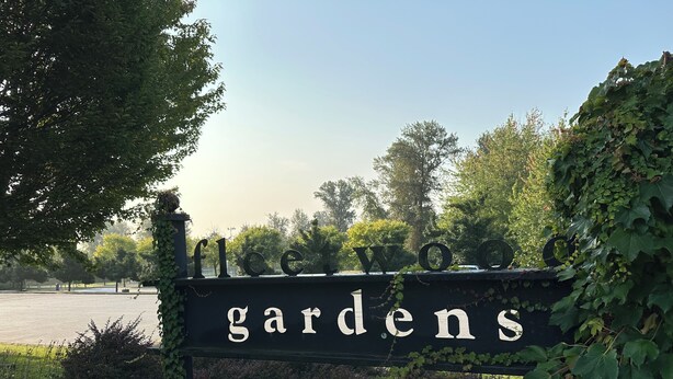 Placa para 'Fleetwood Gardens', com vista clara da vegetação e árvores ao redor.