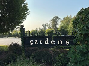 A sign for 'Fleetwood Gardens' with a clear view of the surrounding greenery and trees. - Cozy Dreamscape (Surrey)