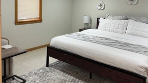 Ein Schlafzimmer mit Bett, Nachttisch, Lampe und Wanddekoration.