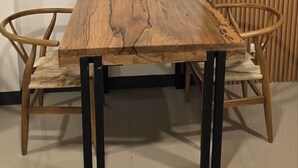 A rectangular wooden table with metal legs, flanked by two upholstered chairs with wooden frames. - Flat 35  (Las Piñas)