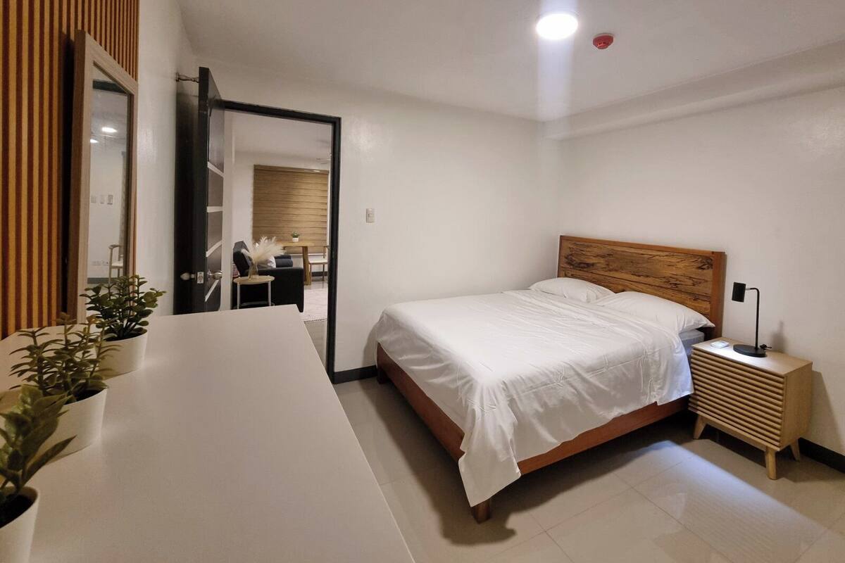 Ein modernes Schlafzimmer mit einem großen Bett, einem Nachttisch und einem Spiegel.