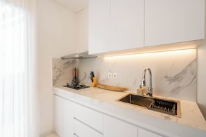 Frigorífico grande, placa de cocina y utensilios de cocina