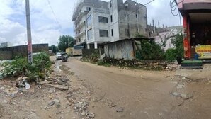 A street scene with buildings, a dirt road, and parked vehicles. - Satvika Guest House (Danta Ramgarh)