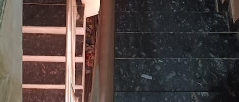 A staircase with black marble steps and a metal handrail.