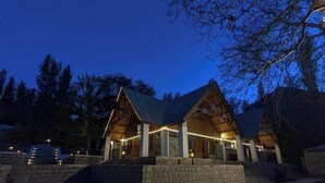 A lodge with a symmetrical roof structure, a stone foundation, and a series of steps leading to the entrance. - Destination Hotel Khaplu (Khaplu)