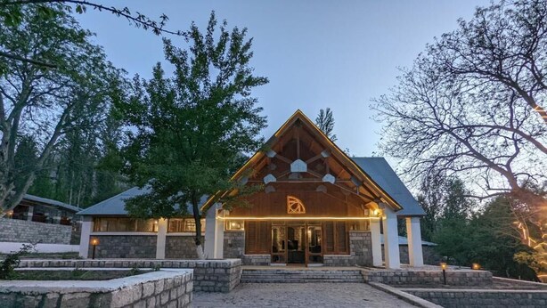 A building with a stone facade, a wooden entrance, and a triangular roof. - Destination Hotel Khaplu (Khaplu)
