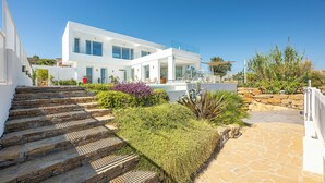 A modern white building with a pool, stone steps, and a stone wall. - Heated Pool Villa / Sea & Gibraltar View (Torreguadiaro)