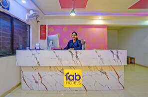 A hotel reception desk with a marble design, a computer, and a logo for 'fab hotels'. - FabHotel Wagholi Inn (Pune)