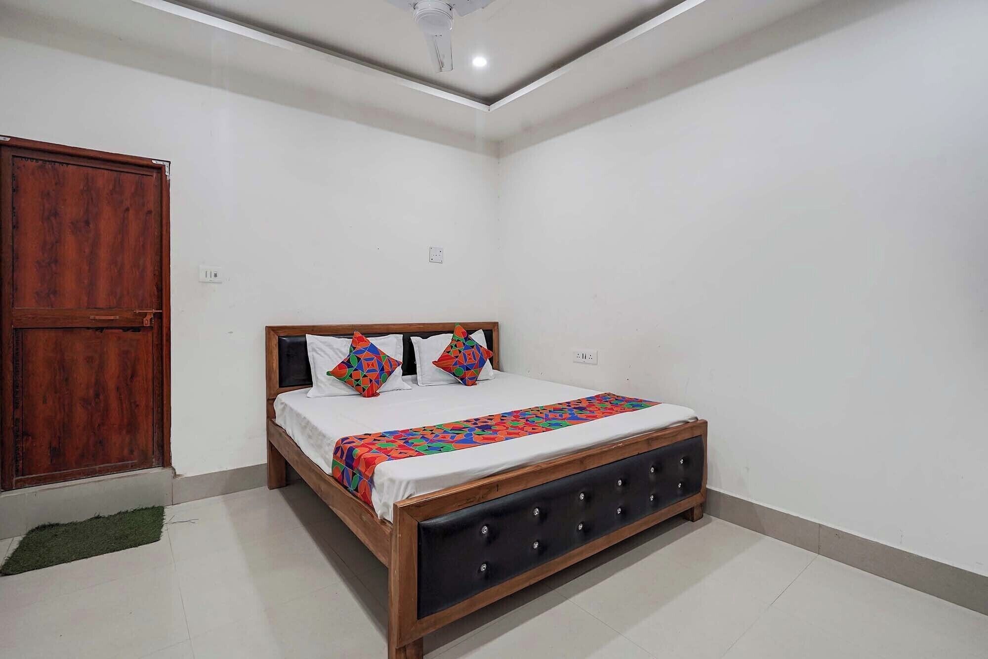 A bedroom with a wooden bed, white walls, and a wooden wardrobe.