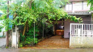 A gated entrance with a tiled pathway leading to a building with a reception desk. - Fabhotel Peaceful Studio Aai Bungalow (Panvel)
