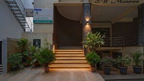 A hotel entrance with a staircase, potted plants, and a sign for 'Blooms Inn' service apartments. - Fabhotel Delight Suite Service Apartments (Bangalore)