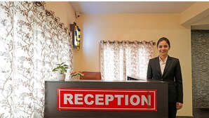 A reception desk with a sign that reads "RECEPTION" in a hotel lobby. - Fabhotel Delight Suite Service Apartments (Bangalore)