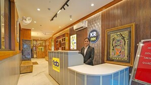 A hotel reception area with a modern design, featuring a reception desk, a sign for 'KR Inn', and a framed artwork on the wall. - Fabhotel Kr Inn (Mathura)