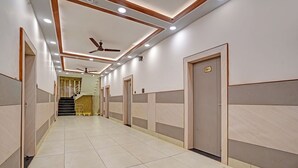 A hallway with a ceiling fan, recessed lighting, and a staircase leading to an upper level. - Fabhotel Kr Inn (Mathura)