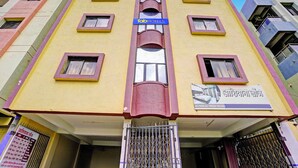 A multi-story building with a yellow facade, multiple windows, and a sign for 'TabHOTELS'. - Fabhotel Ashiyana (Pune)