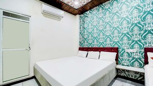 A bedroom with a bed, a wardrobe, and a patterned wall. - Fabhotel Mahak Palace (Ujjain)